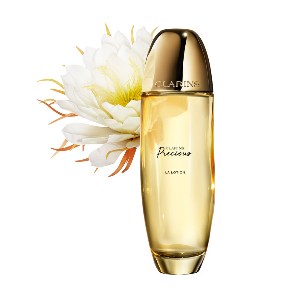 Packshot of Clarins Precious Treatment Essence close to a Moonlight flower on a dark background.