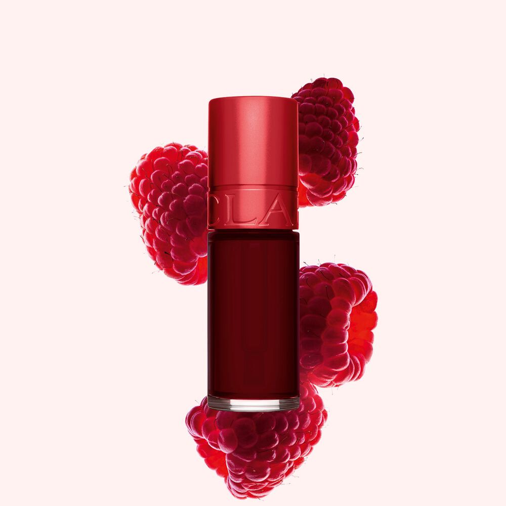 Packshot of Clarins dark Red Water Lips Stain in shade 9, placed beside rasberries on a light pink background.