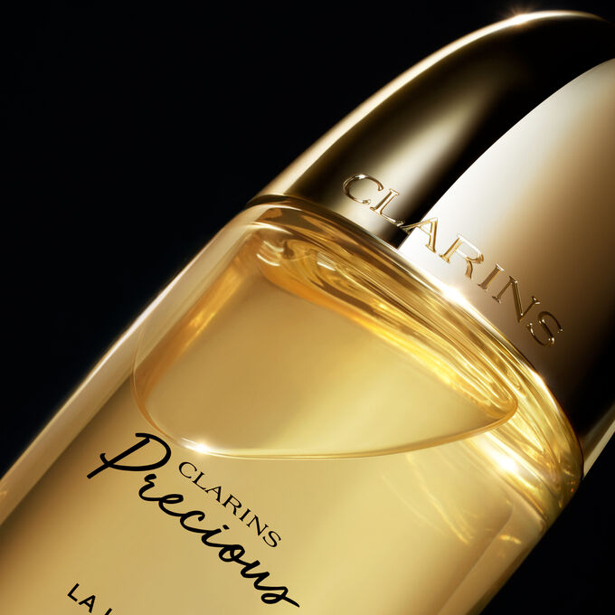 Packshot of Clarins Precious Treatment Essence, with text emphasising its power to hydrate, smooth and plump skin.