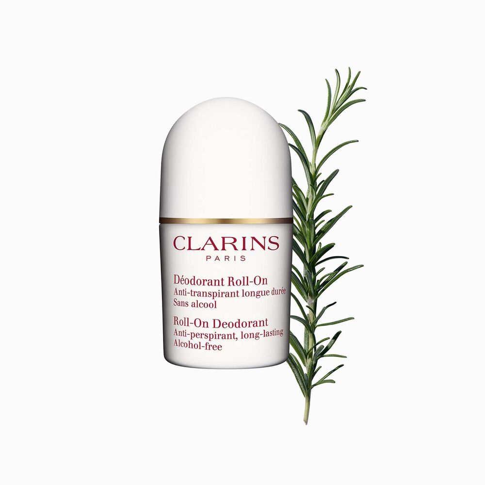Packshot of a Deo roll-on for sensitive skin close to some blades of rosemary on a white background.