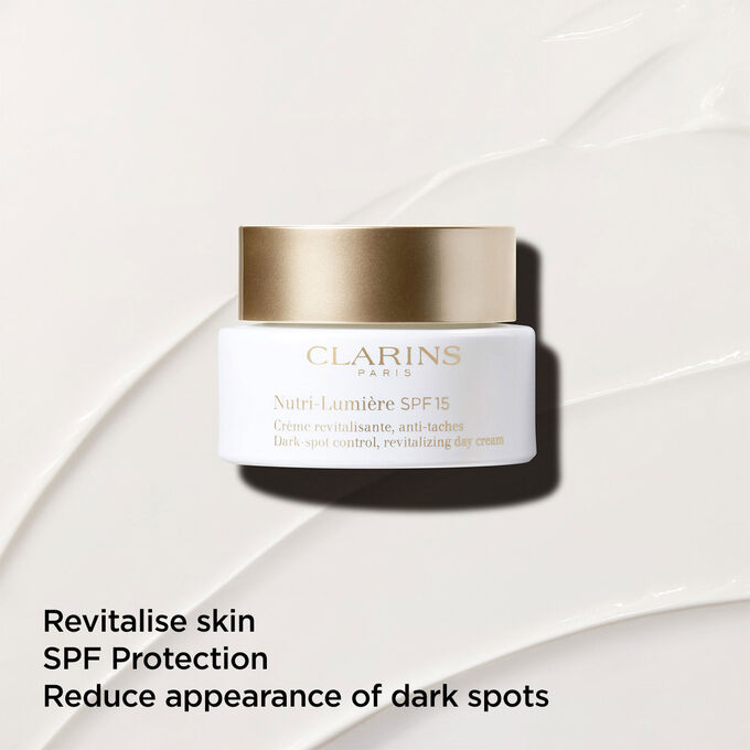 Anti-dark spot day cream with SPF 15 on a textured background, emphasizing its skin revitalizing action