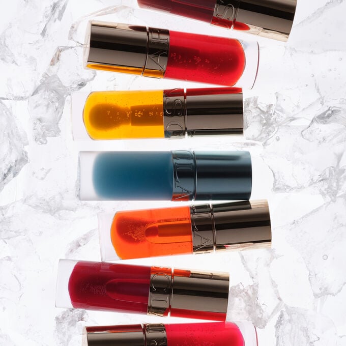 Showcase of all Clarins Lip Comfort Oils on ice, focusing on the new cooling lip oil with its refreshing and soothing effect.