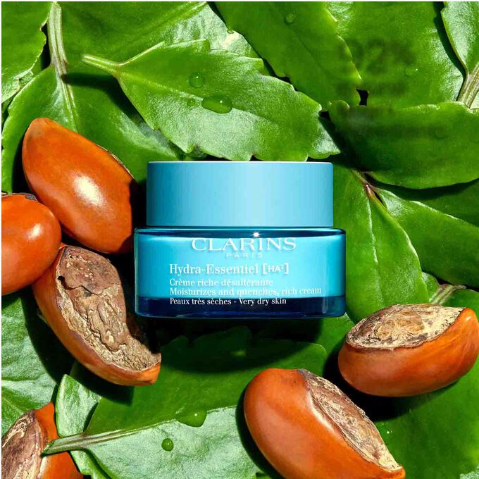 Packshot of Clarins Hydra-Essentiel 23 Rich Cream among leaves and shea nuts, highlighting its 92% natural origin ingredients