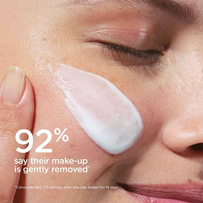 Focus on the facial milk application on a woman's cheek to illustrated that 92% of testers find the make-up removing smooth