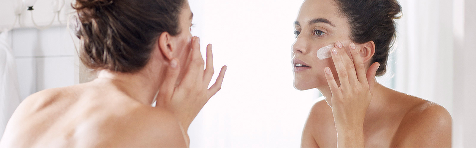 Woman moisturising her face
