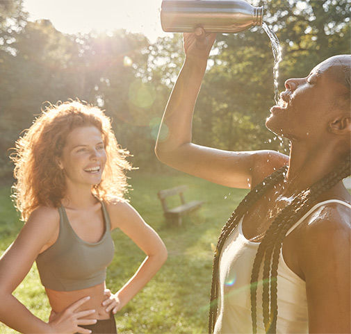 2 young women drinking water and laughing